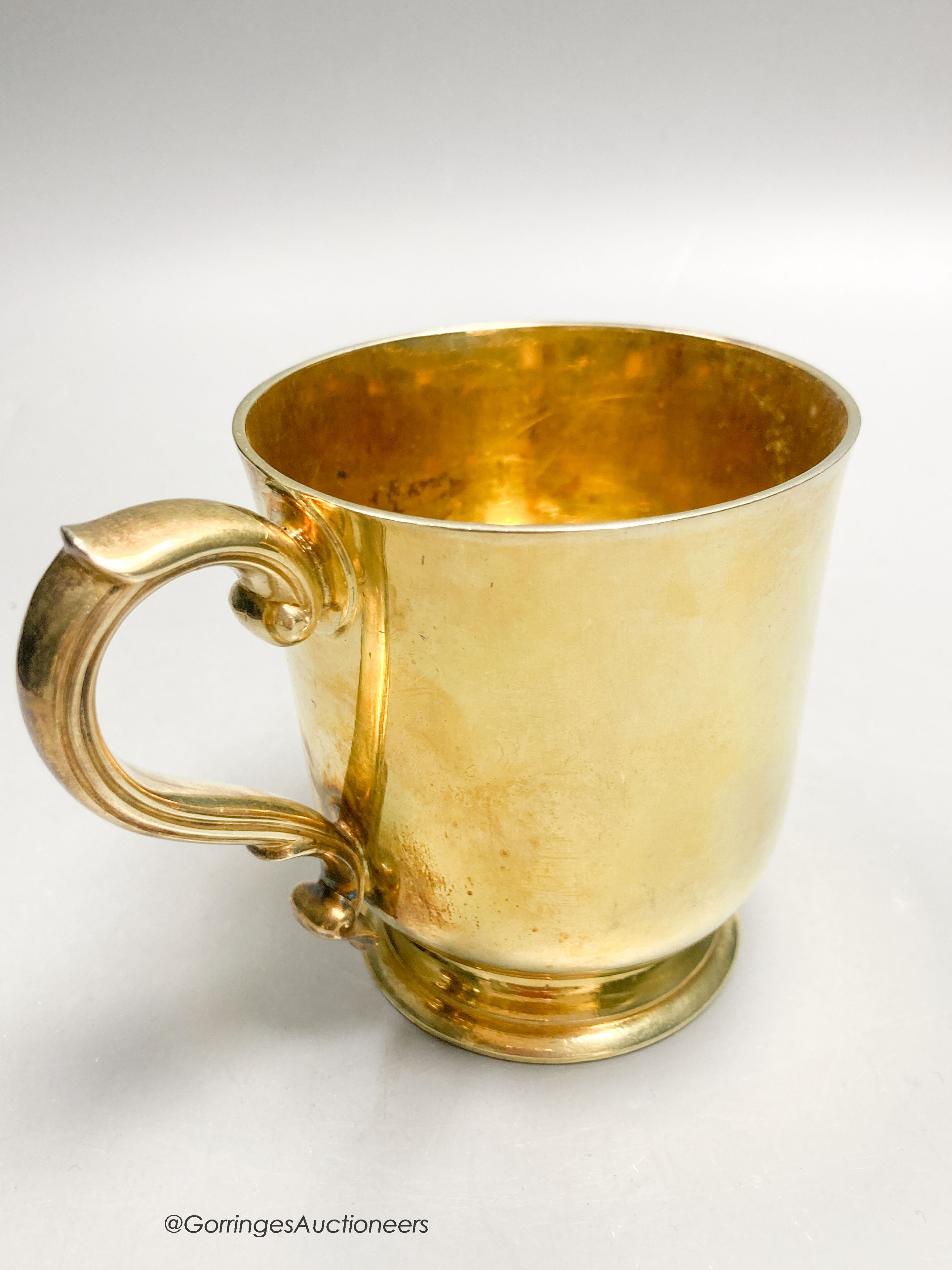 A Victorian silver gilt christening mug, by R & S. Garrard & Co, London, 1873, height 82mm, 7oz, in associated leather carrying case.